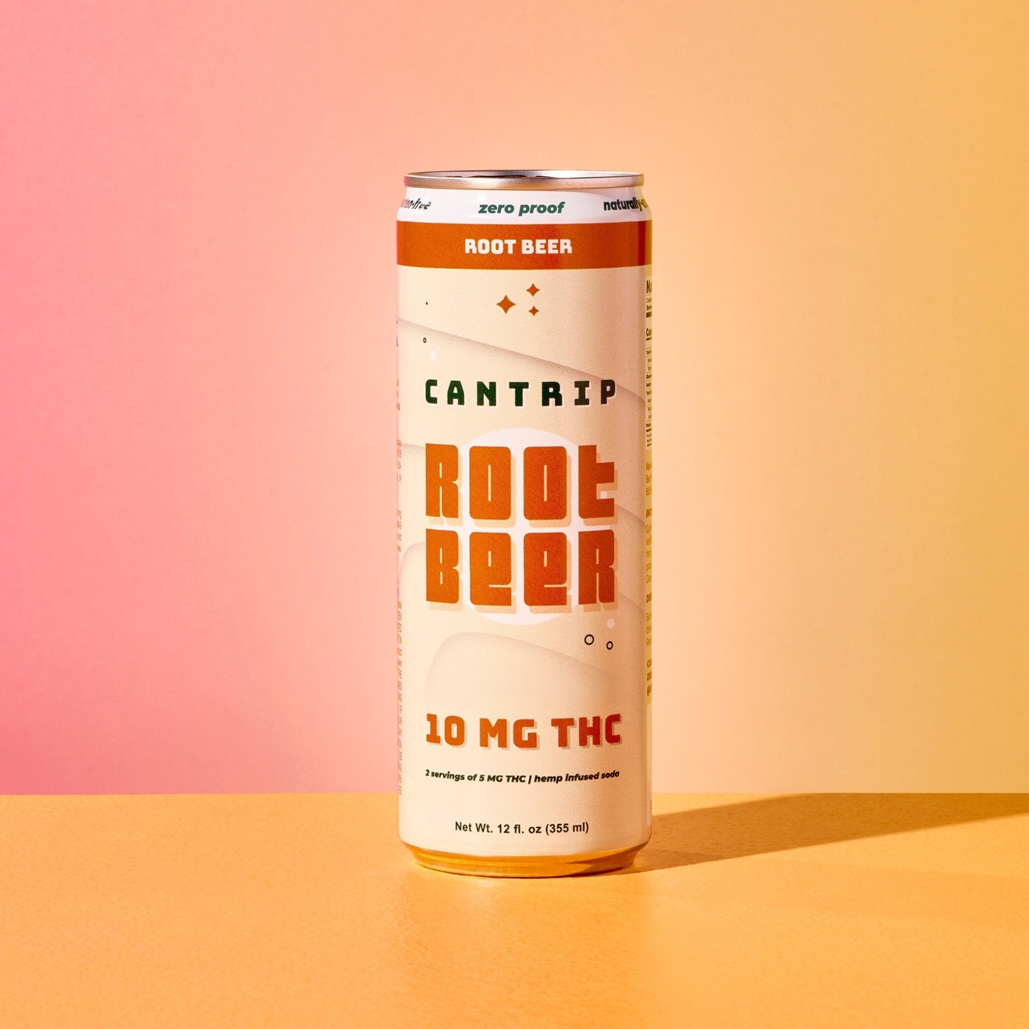 A cream-colored can of Cantrip 10 MG THC Root Beer sitting on an orange table.