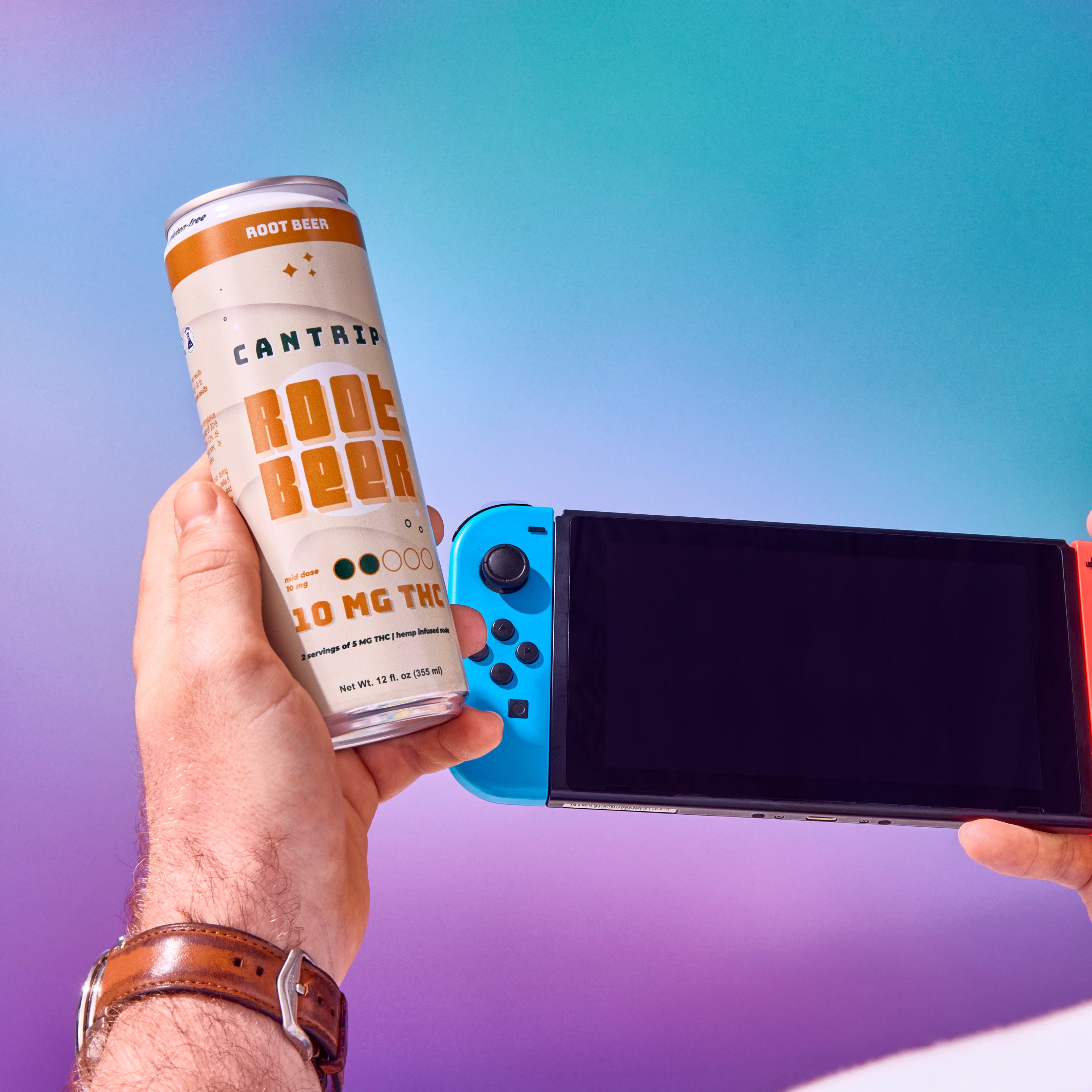 A can of 10mg THC Root Beer in someone's hand, along with a gaming console.