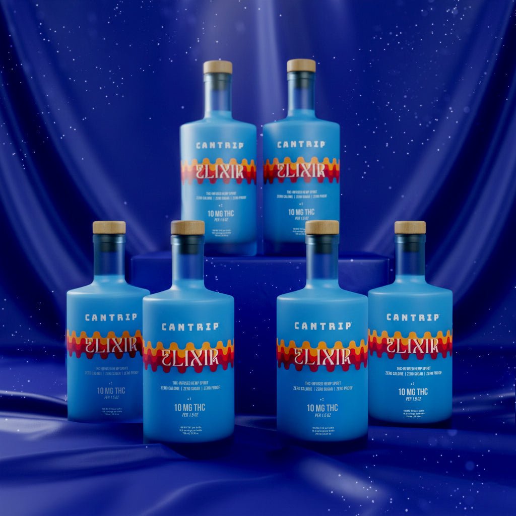Six blue bottles of Cantrip Elixir, a hemp-infused spirit, stacked in front of a blue curtain