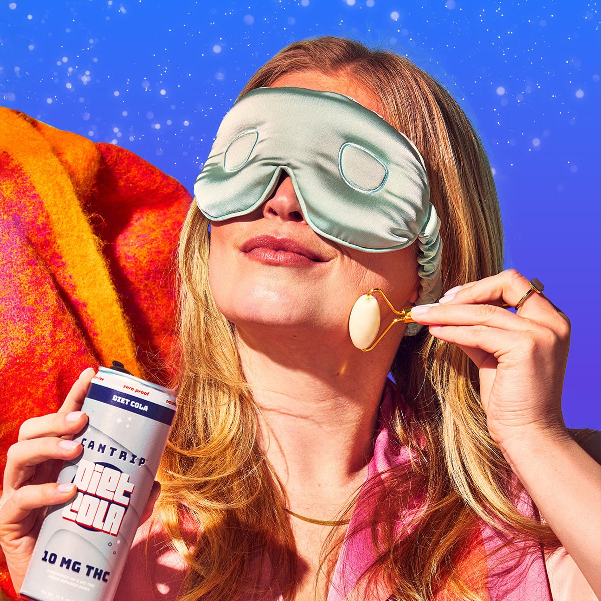 A red-haired woman wearing a mint green sleep mask smiles gently while holding a can of Cantrip THC Diet Cola.