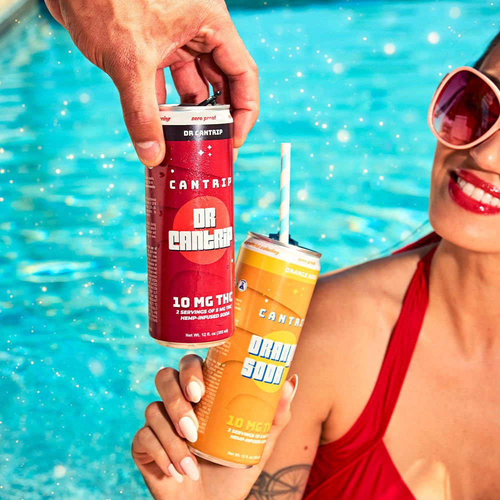 Two people clinking cans of Cantrip soda by a pool.