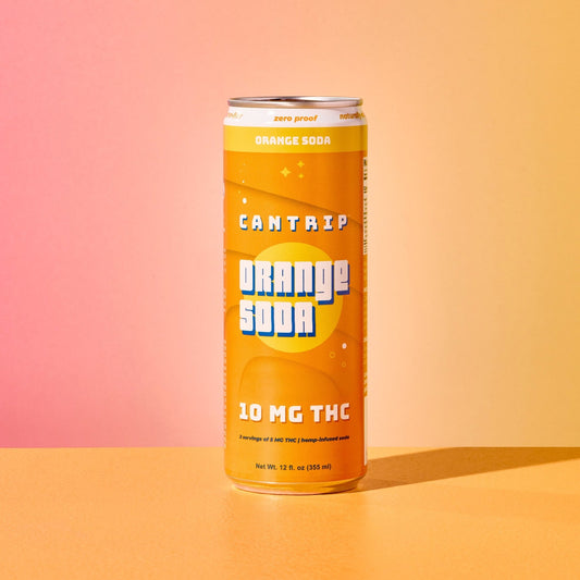 An orange-colored can of Cantrip 10 MG THC Orange Soda sitting on an orange table.