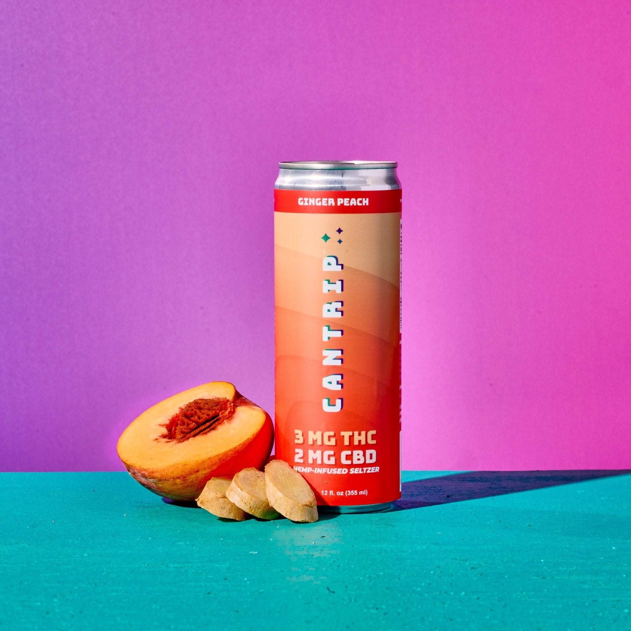 A peach-colored can of Cantrip Ginger Peach THC Seltzer. Half of a fresh peach and slices of ginger root rest against the can.